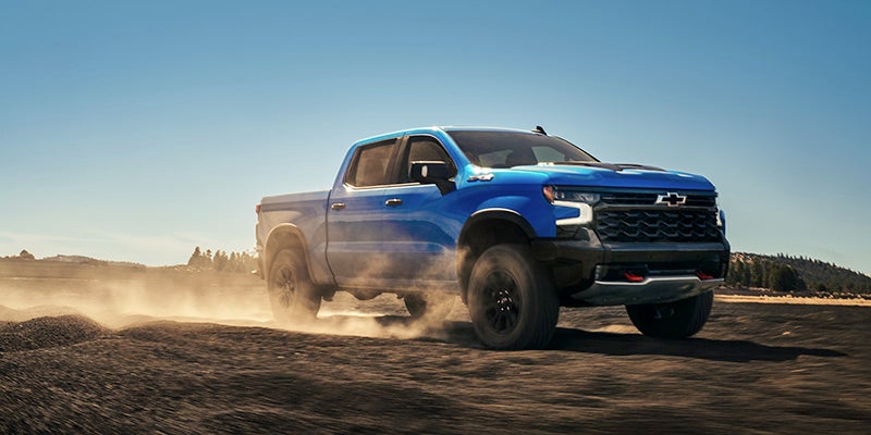 the 2025 Chevrolet Silverado 1500 driving down a dirt road in the mountains